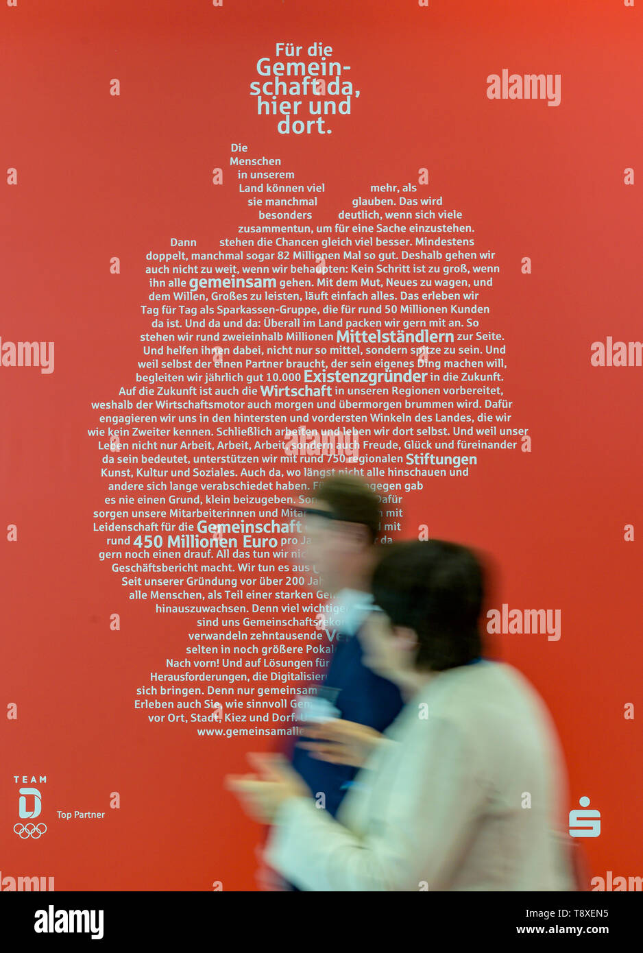 Hamburg, Germany. 15th May, 2019. Visitors to the 26th German Savings Banks Day walk along the Sparkasse in front of an advertising poster showing the outline of the map of Germany. Credit: Axel Heimken/dpa/Alamy Live News Stock Photo