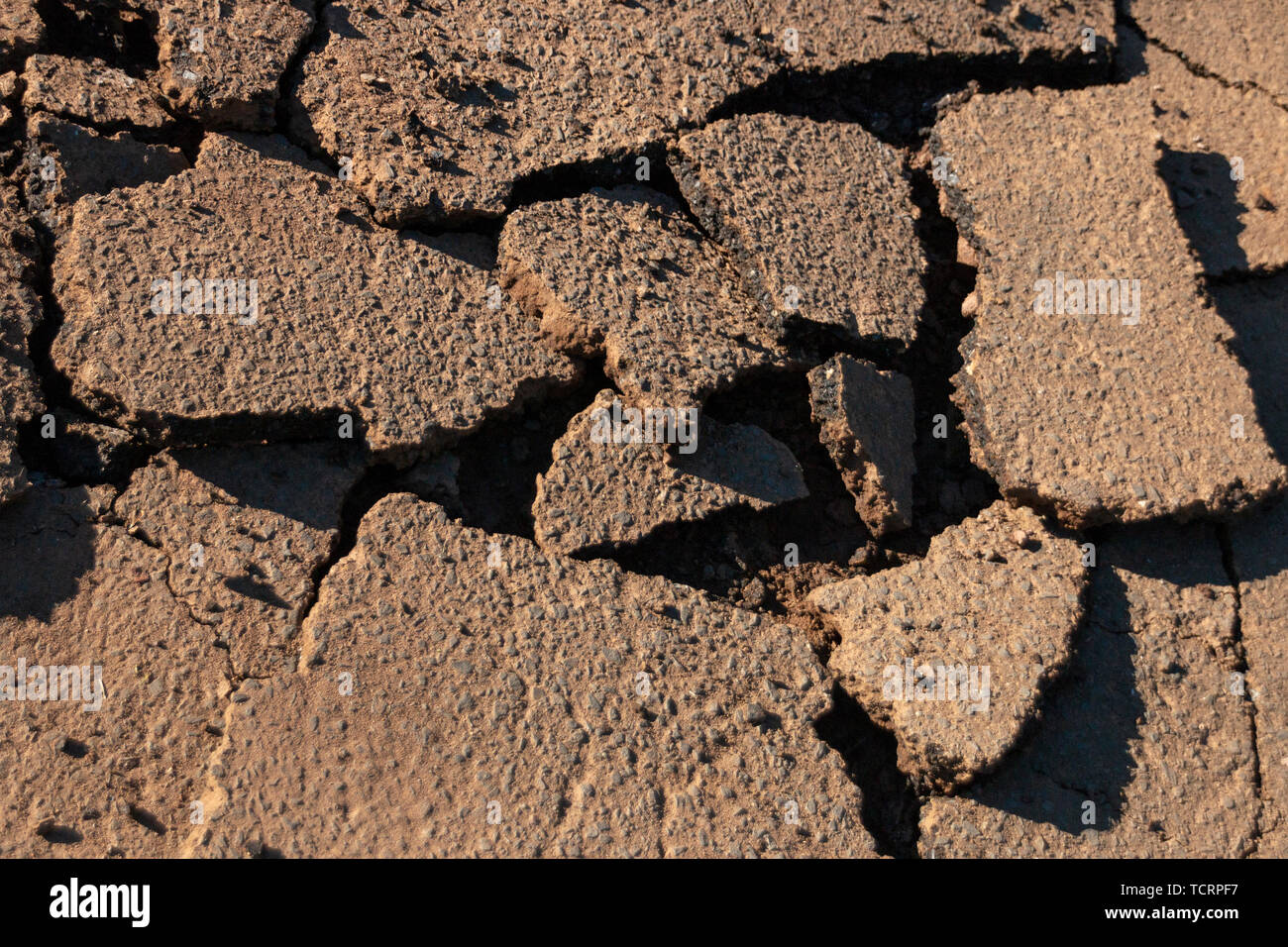 A close up view of an old driveway where the tar has been broken up into differant size pieces so that new tar can be layed. Stock Photo