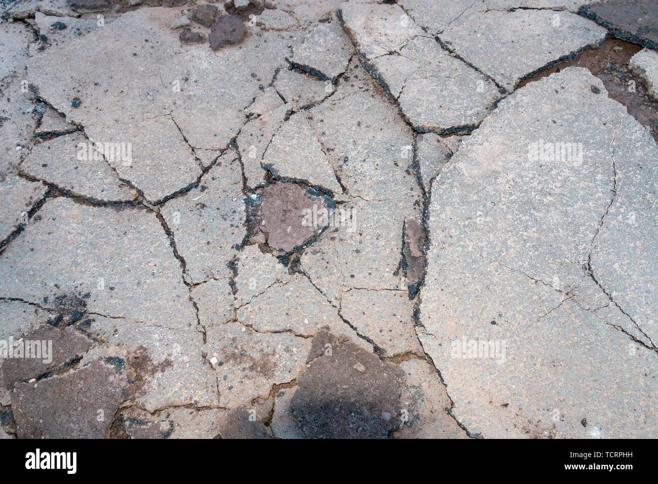 A close up view of an old driveway where the tar has been broken up into differant size pieces so that new tar can be layed. Stock Photo