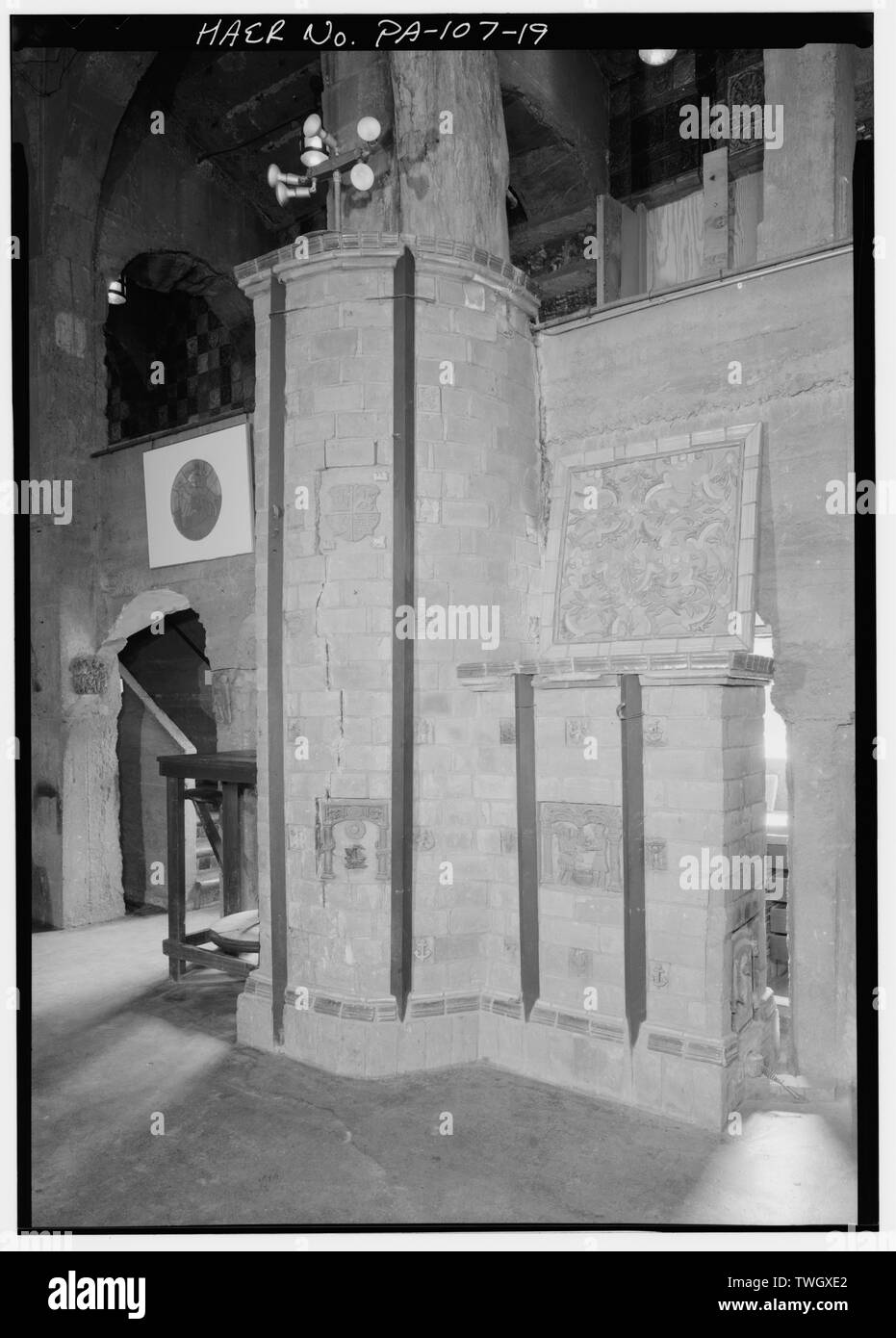 RUSSIAN STOVE IN THE INDIAN HOUSE. FIREBOX IS AT THE LOWER RIGHT. THE FOOT-POWERED POTTER'S WHEEL IN THE BACKGROUND WAS COLLECTED BY HENRY MERCER, BUT WAS NOT USED IN PRODUCTION. - Moravian Pottery and Tile Works, Southwest side of State Route 313 (Swamp Road), Northwest of East Court Street, Doylestown, Bucks County, PA; Mercer, Henry Chapman; Swain, Frank King; Briddes, John; Sell, Herman; American Clay Machinery Company; Crossley Manufacturing Company; Donegan and Swift; Orr and Sembower; Buck, Raymond; Swain, Frank H; Bucks County Department of Parks and Recreation; Bailey Pottery Equipmen Stock Photo