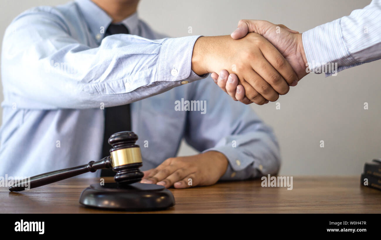 Handshake after consultation between a male lawyer and client, giving advice and prosecutions about the regarding real estate. Stock Photo