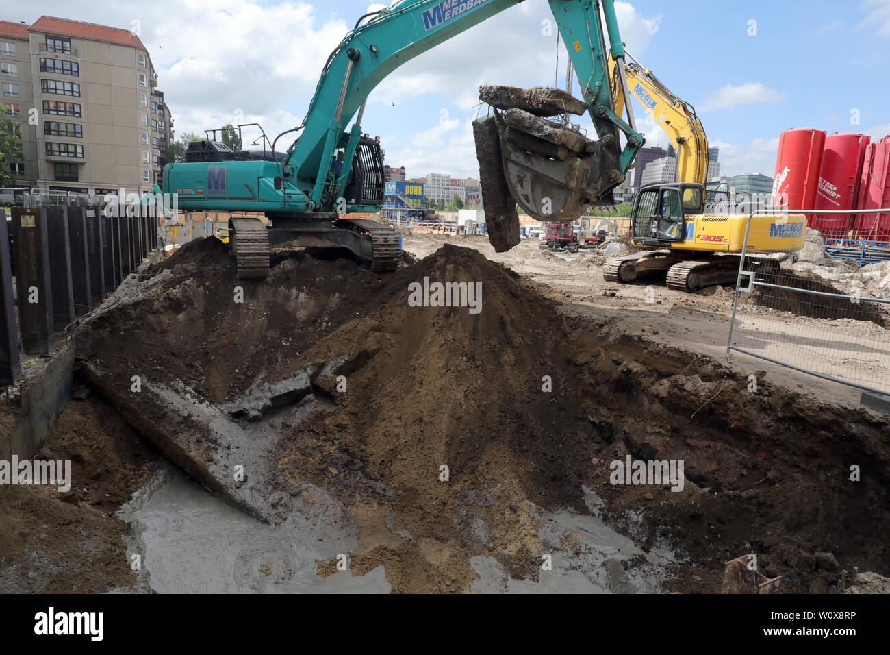 Berlin, Germany. 19th June, 2019. Excavators are digging out the remains of a bunker from the NS era on Behrenstraße in the Mitte district. On this site, where the Reich Ministry of Food and Agriculture and the building of the Reich President once stood, a new building with underground car park is being erected. In the background on the left were residential buildings on Wilhelmstraße and Vossstraße, where other ministries and the Reich Chancellery with the Führer bunker were located. Credit: Wolfgang Kumm/dpa/Alamy Live News Stock Photo