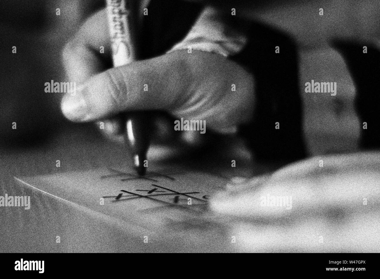 Person writing and drawing in black and white with grain Stock Photo