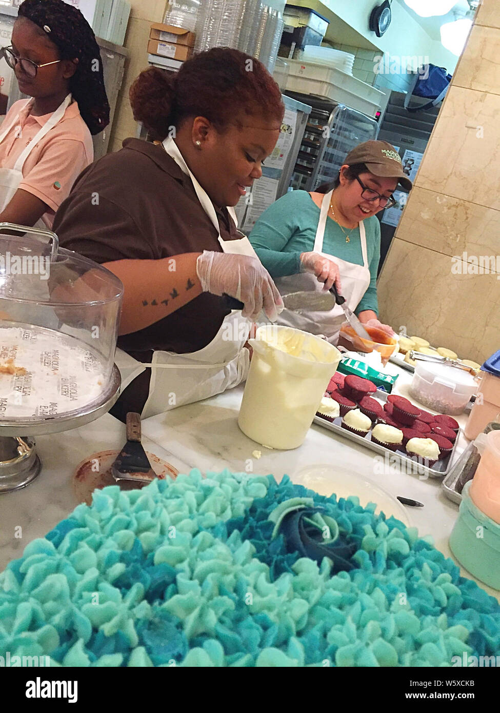 Workers Frosting Cupcakes, Magnolia Bakery, Grand Central Terminal, NYC, USA Stock Photo