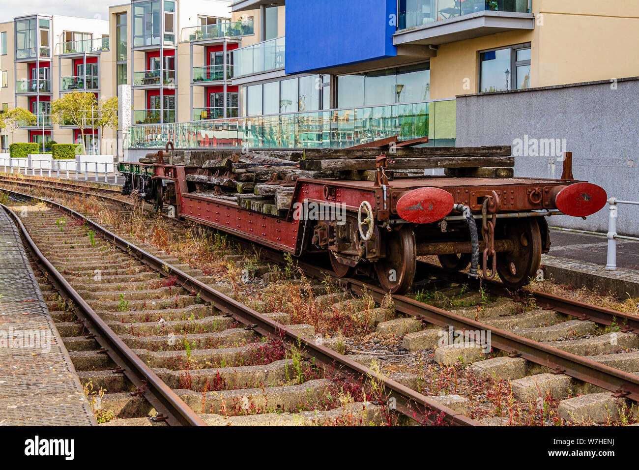 A disused truck on the heritage Harbour Railway on Bristol quayside in front of modern apartment flats on Museum Street. Bristol, UK. July 2019. Stock Photo