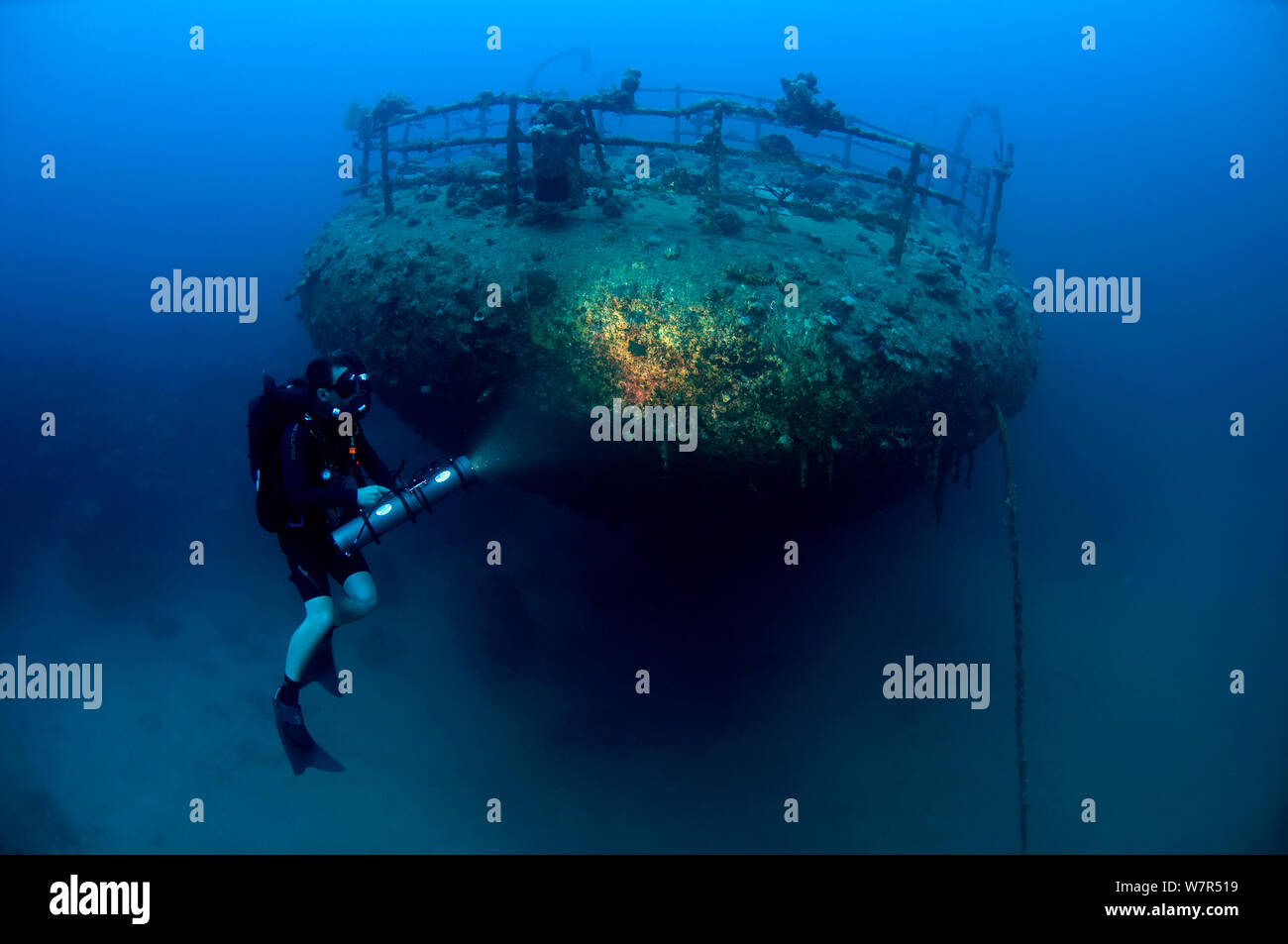 Wreck of the cargo ship 'Iouna'. Diver and ships stern with navigation light still attached on rail. Wrecked between 1912-1918. Sharmo reef, Yanbu, Saudi Arabia, July 2010 Stock Photo