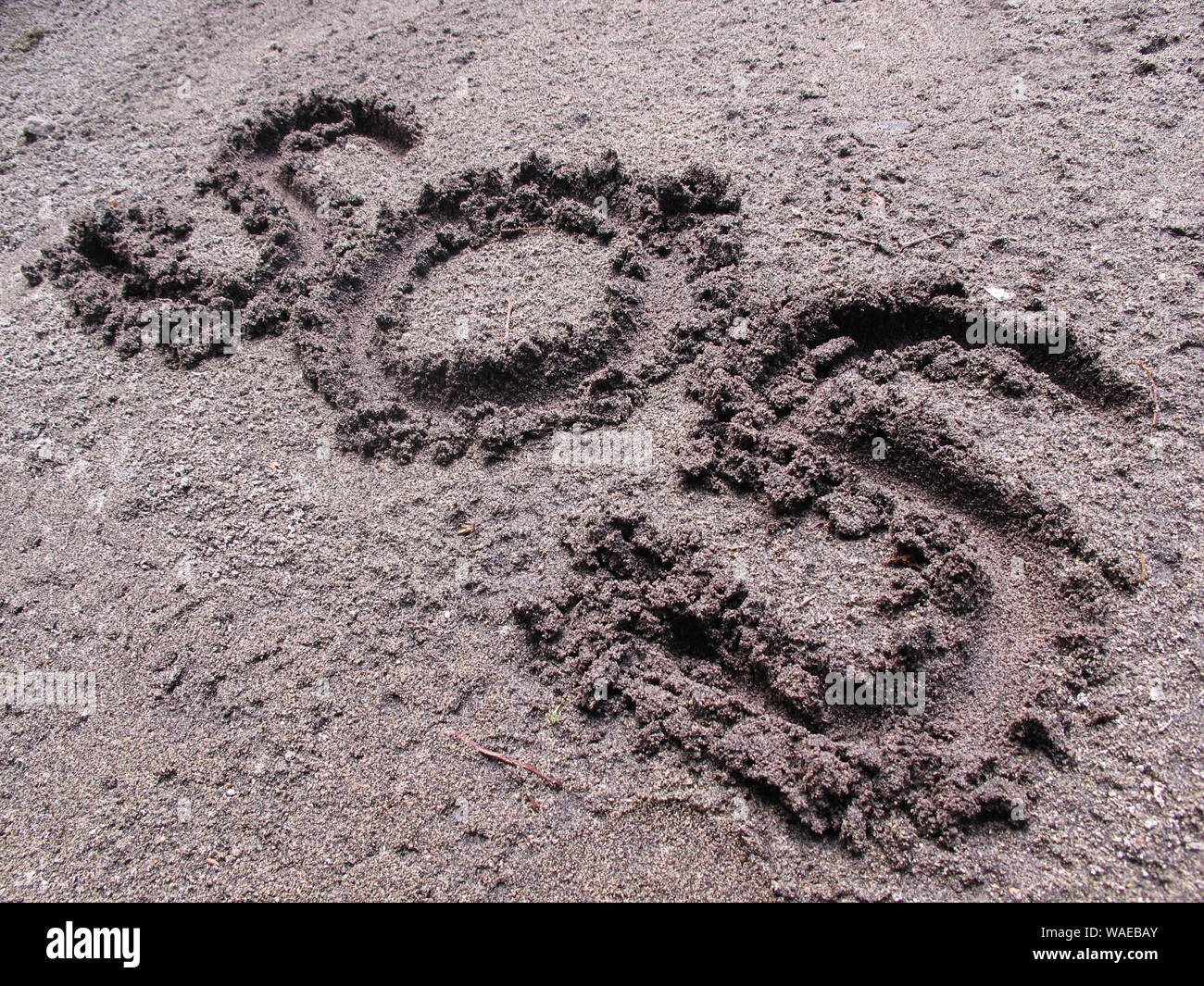 SOS sign written on the ground Stock Photo