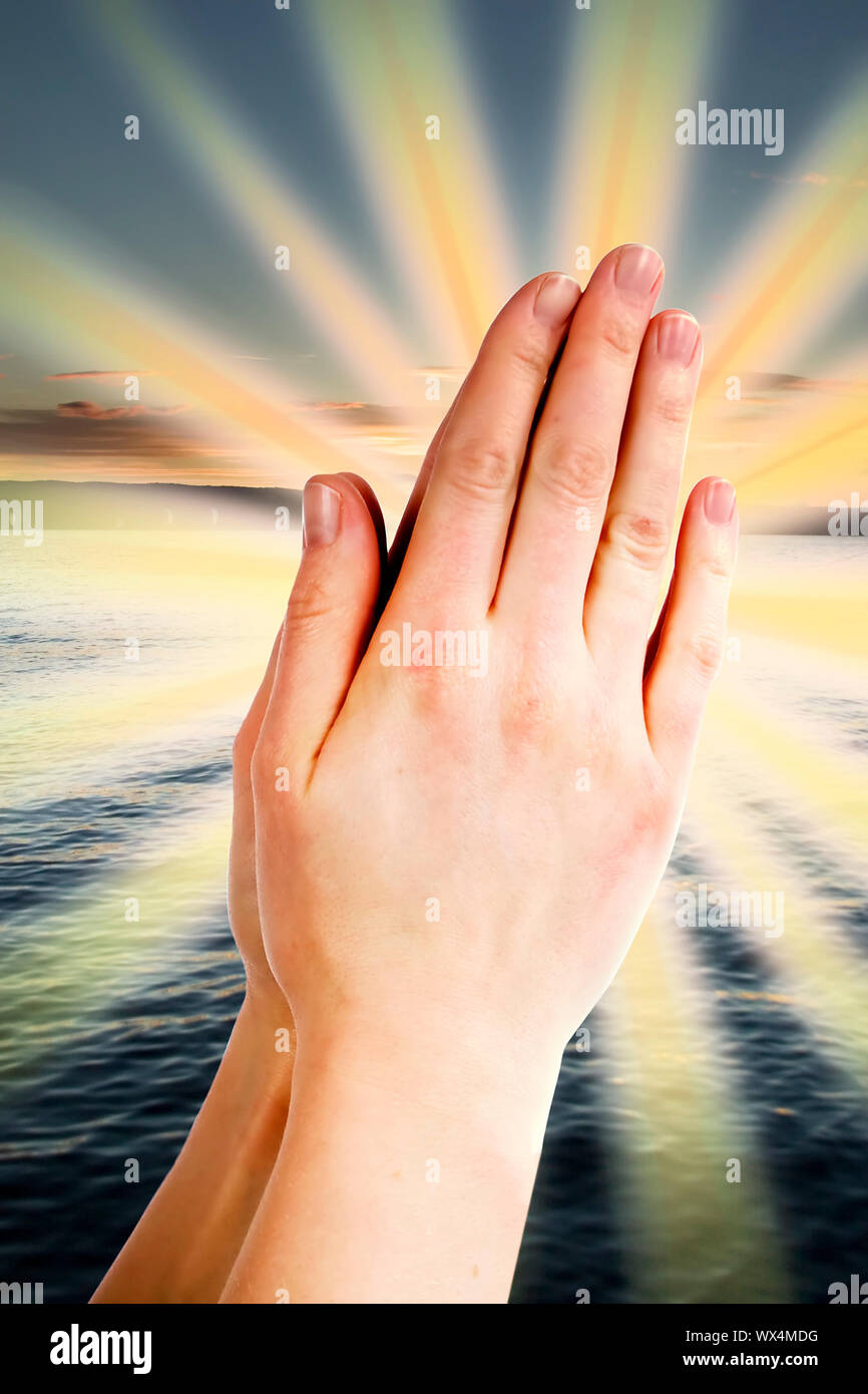 Praying hands with a landscape with the ocean and a sunset in the background  Stock Photo - Alamy