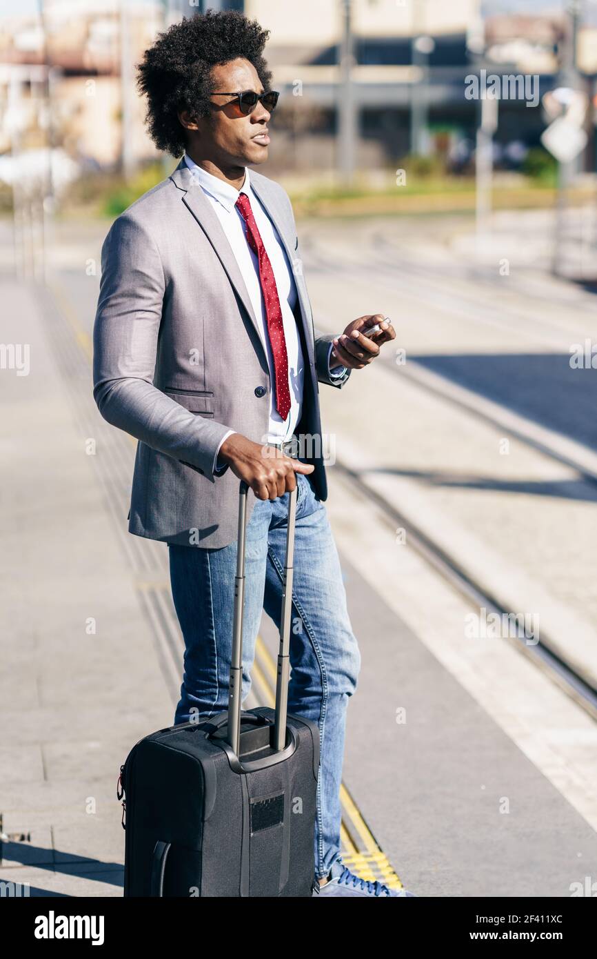 Schwarzer Geschäftsmann wartet auf den nächsten Zug. Mann mit afro Haar pendeln.. Schwarzer Geschäftsmann wartet auf den nächsten Zug Stockfoto