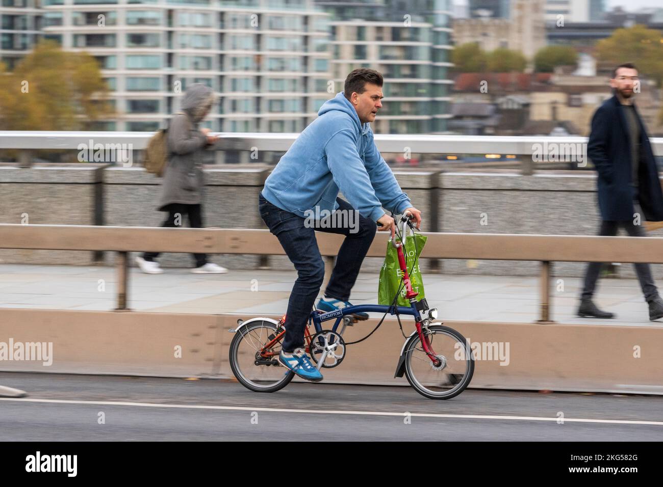 Ein Mann pendelt während der Hauptverkehrszeit auf einem Brompton-Faltfahrrad über die London Bridge, London, Großbritannien. 16. November 2022 Stockfoto