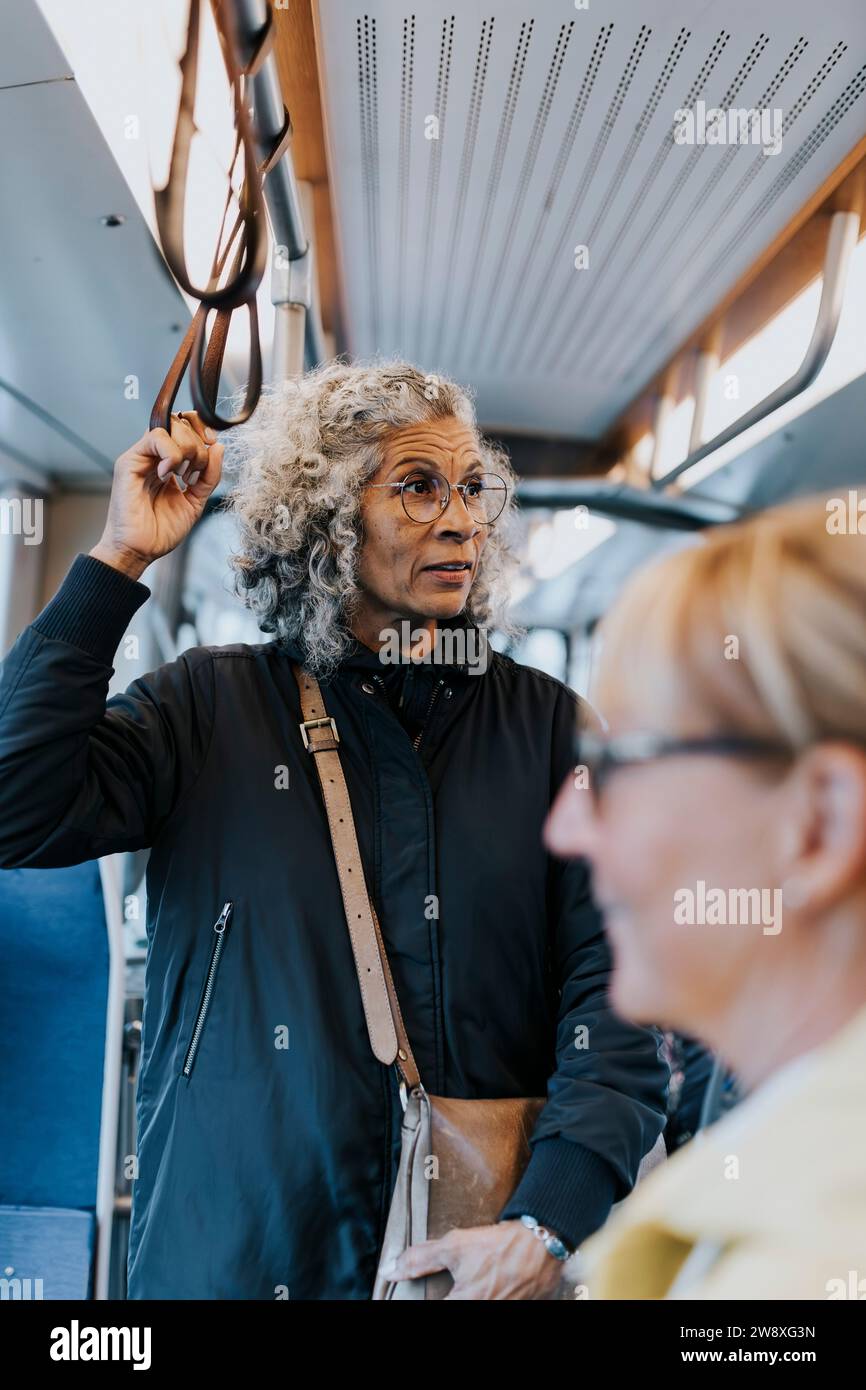 Besinnliche Unternehmerin, die wegschaut, während sie mit dem Bus pendelt Stockfoto