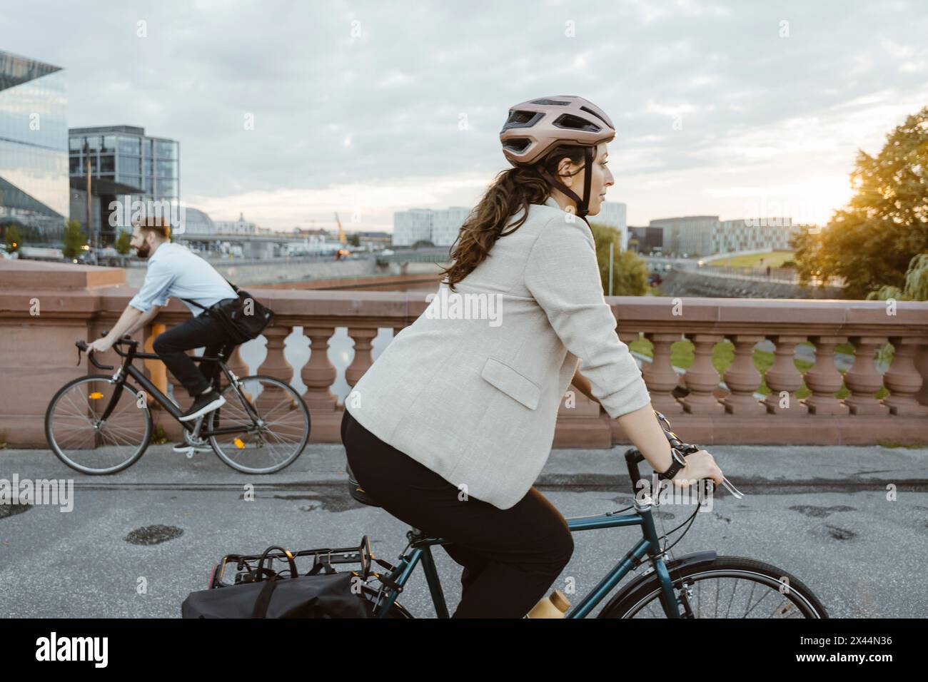 Geschäftsfrau mit Helm und auf dem Fahrrad in der Stadt Stockfoto