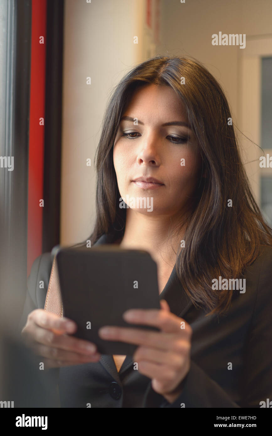 Ein Porträt von attraktive Brünette Frau mit Tablet im Zug, beim Pendeln von der Arbeit Stockfoto