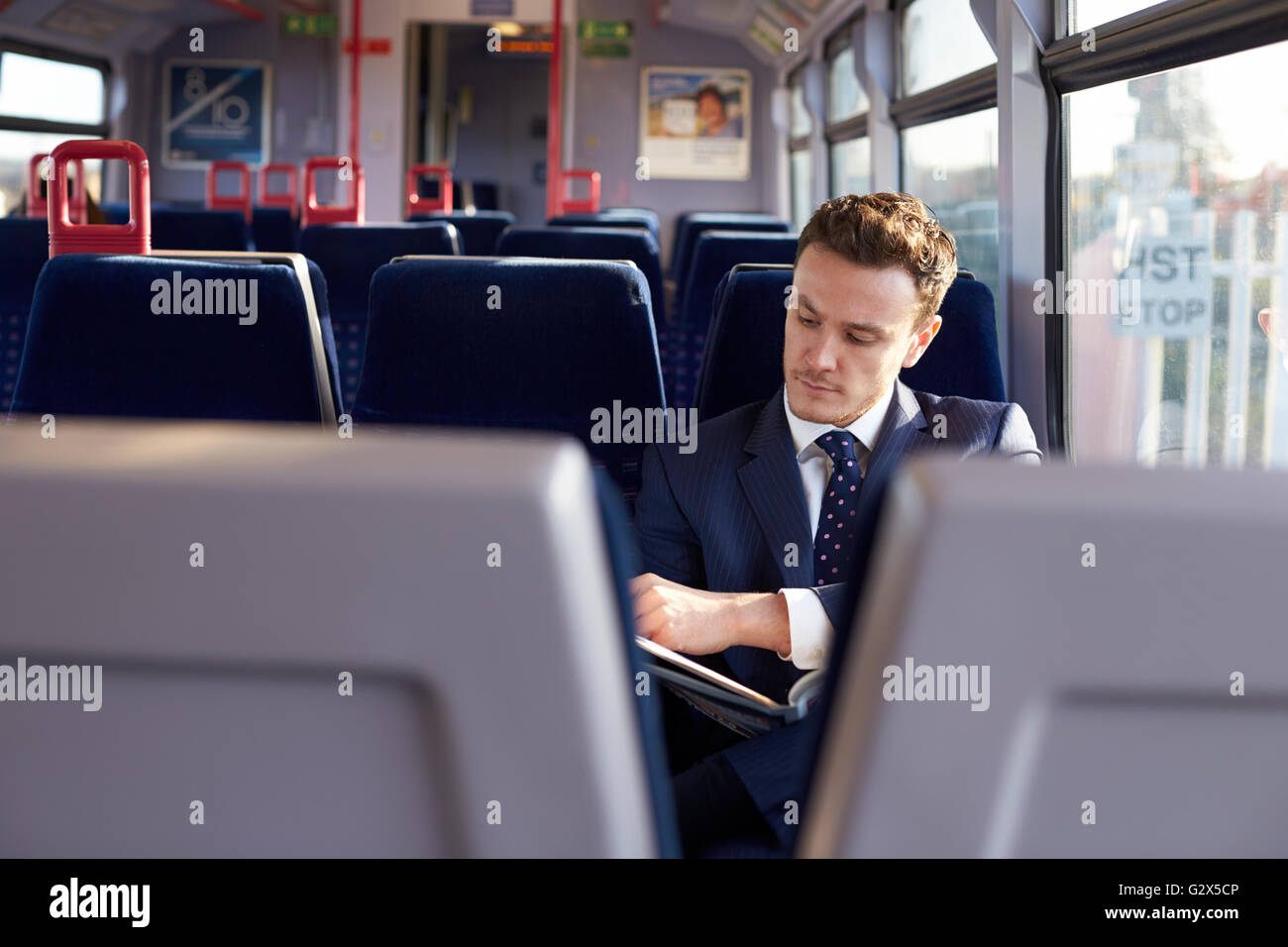 Geschäftsmann pendeln zur Arbeit, Zeitunglesen auf Zug Stockfoto