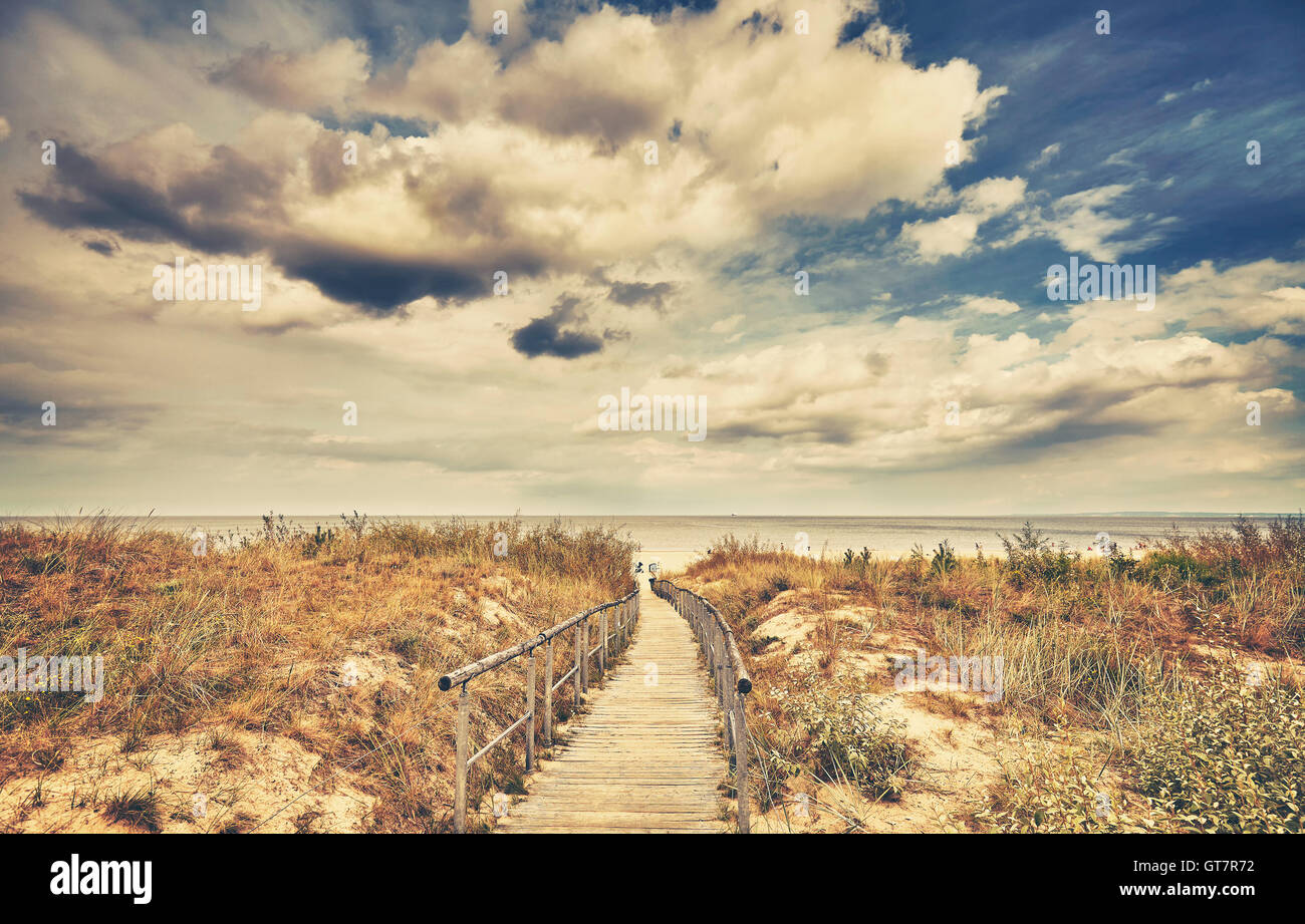 Retro getönten Holz Wanderweg führt zu einem Strand an einem bewölkten Tag. Stockfoto