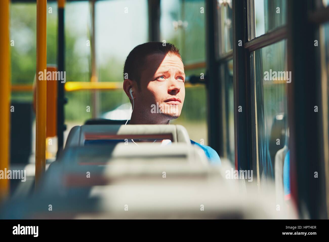 Alltag und pendeln zur Arbeit mit öffentlichen Verkehrsmitteln. Hübscher junger Mann ist mit der Straßenbahn unterwegs. Stockfoto