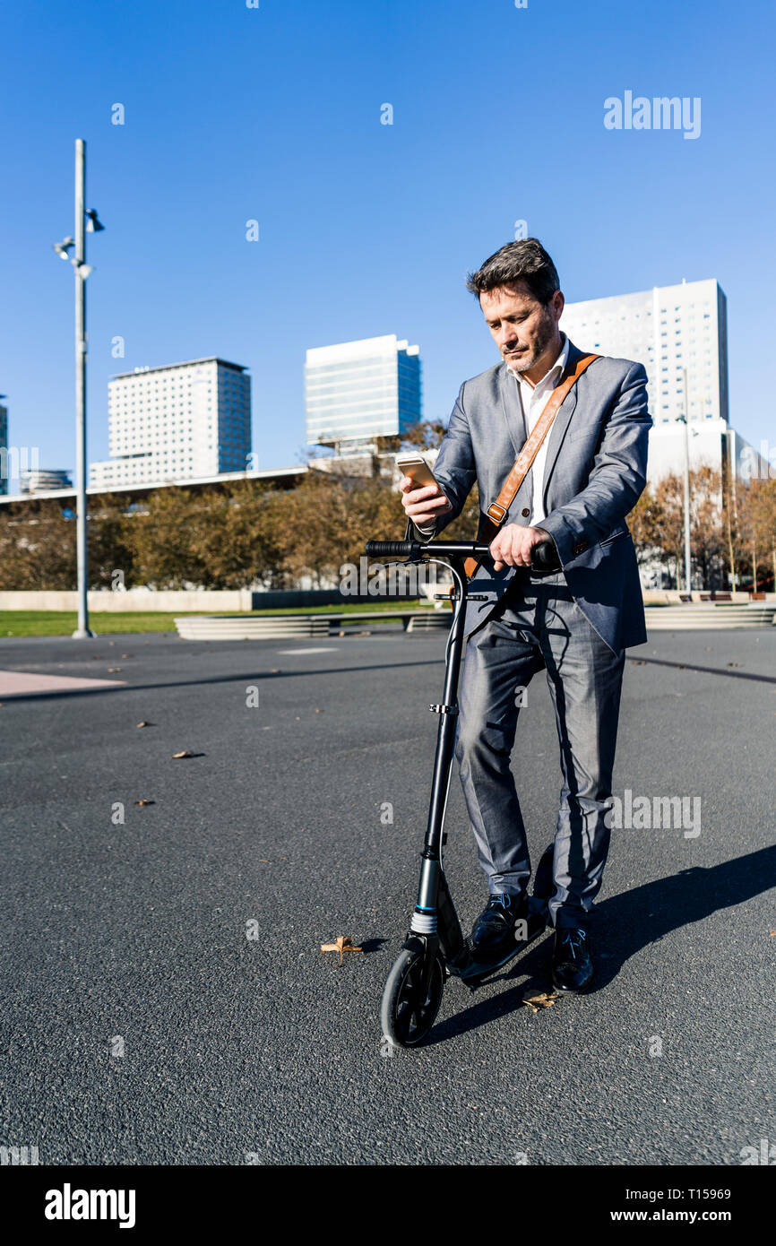 Reifen Geschäftsmann in der Stadt pendeln mit seinen kick Scooter Stockfoto