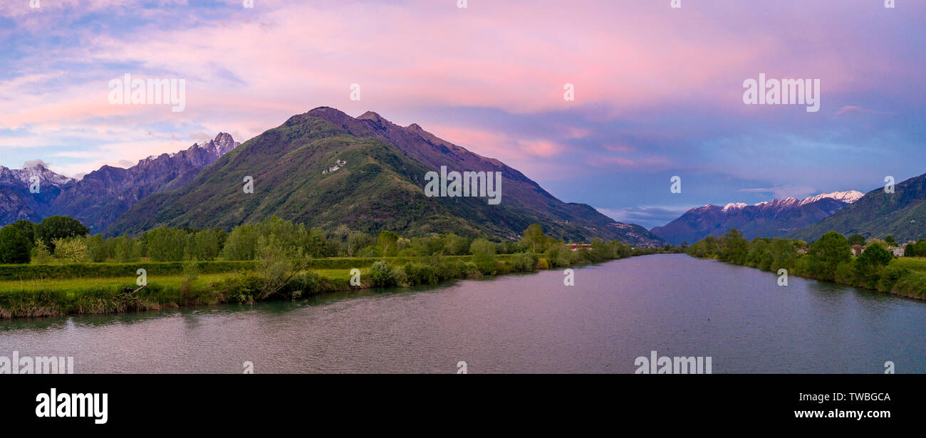 Antenne Panoramablick auf den Sonnenuntergang über den Fluss Adda und Rhätischen Alpen, Sondrio Provinz, untere Veltlin, Lombardei, Italien Stockfoto