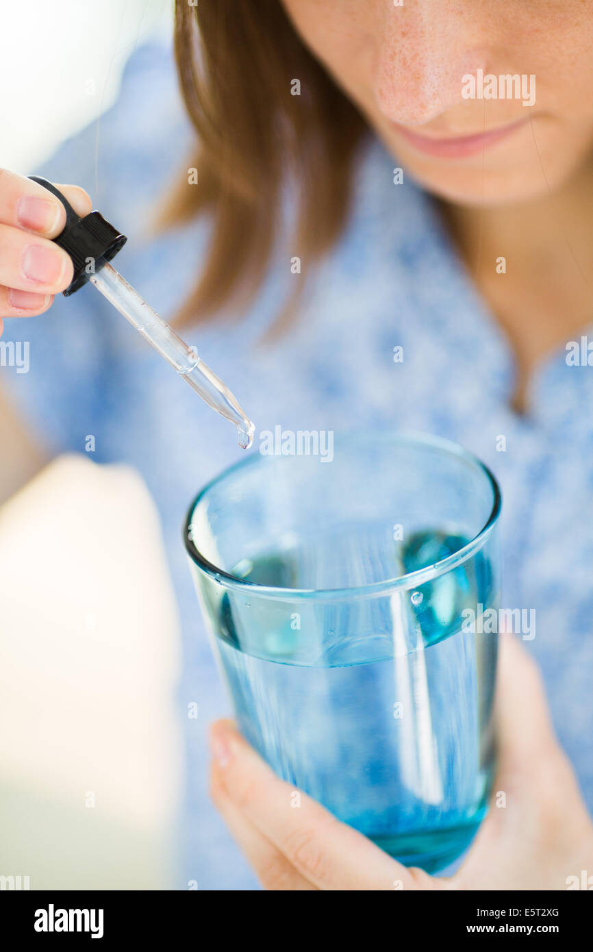 Woman taking gouttes de la médecine. Banque D'Images