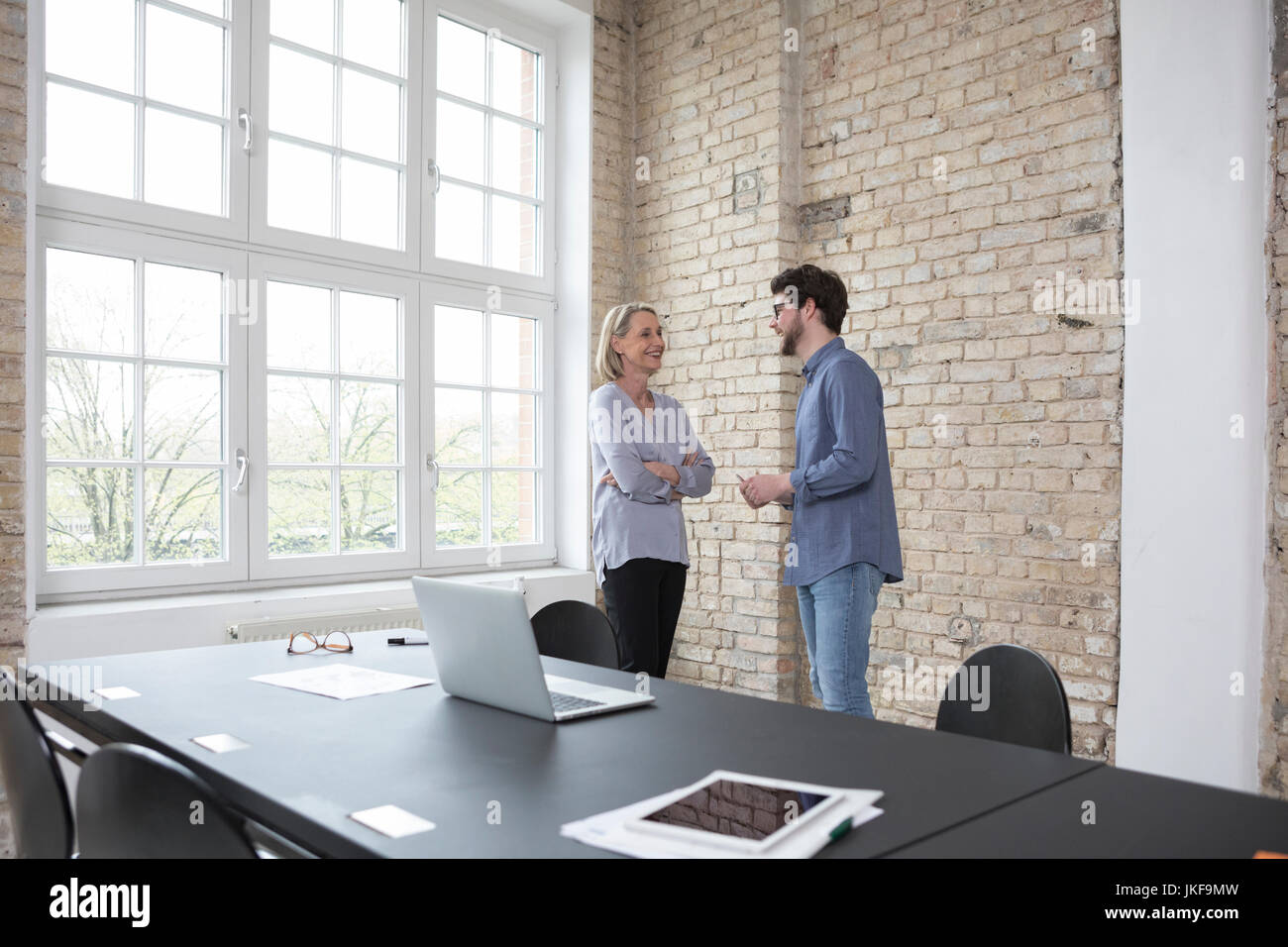 Femme mature avec jeune collègue de travail in office Banque D'Images