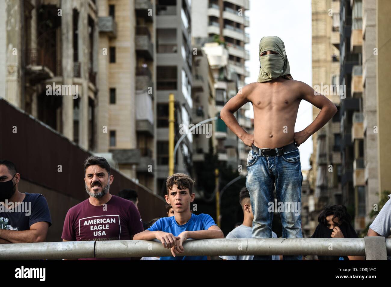 Beirut, Libano, 30 ottobre 2020. Gli spettatori guardano come un piccolo gruppo di uomini di Tripoli e Beirut si scontrano con le forze libanesi per la sicurezza interna durante un tentativo del gruppo pan-islamico Hizb Ut Tahrir di marciare all'ambasciata francese per protestare contro ciò che essi guardano come la posizione anti-islamica del presidente Emmanuel Macron. Le emozioni hanno corso alto come è stato sentito il profeta Maometto è stato disrispettato durante il suo mese di compleanno. Credit: Elizabeth Fitt/Alamy Live News Foto Stock