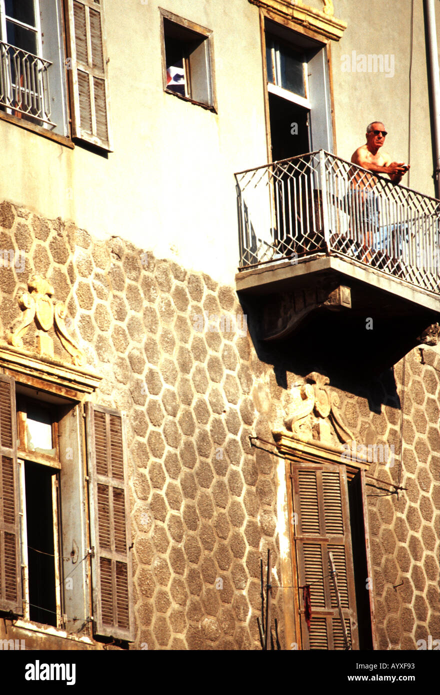 Stile coloniale francese edificio con uomo a prendere il sole sul balcone Achrafiye Beirut Libano Foto Stock