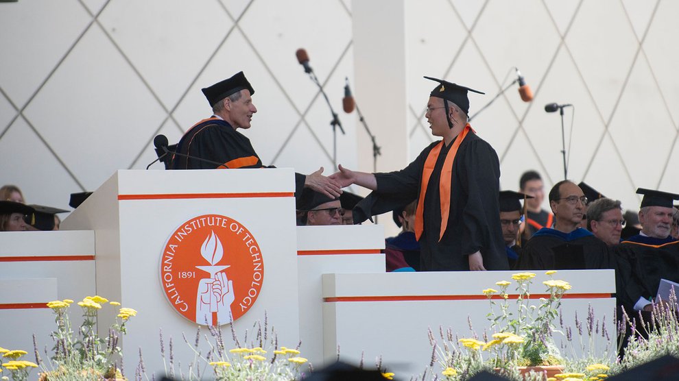 President Rosenbaum shakes a graduate's hand on stage.