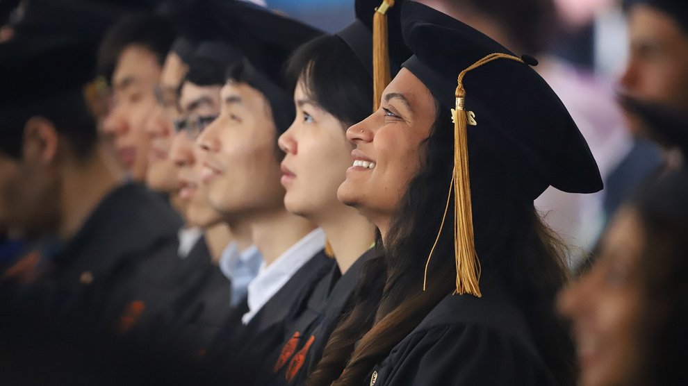 A doctoral graduate smiles during the Commencement program.