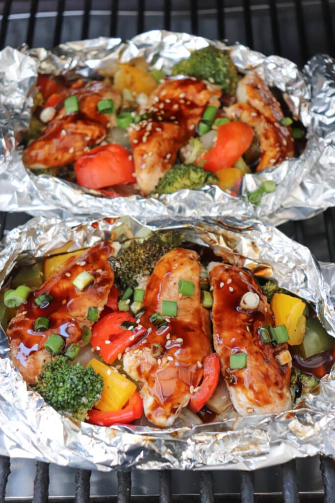 Teriyaki chicken in foil packs on the grill.