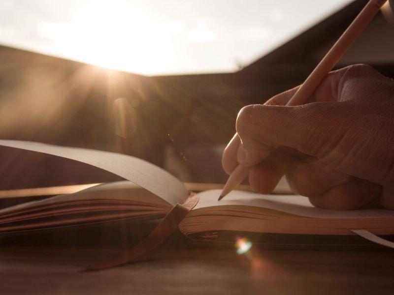 Image showing a researcher writing in a notepad to illustrate advice on using poetry to analyse data