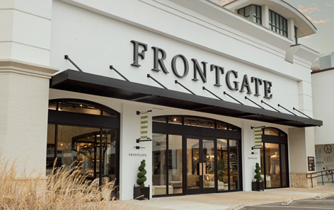 An exterior photo of the Frontgate retail store. There is a black awning that compliments the stark white building.