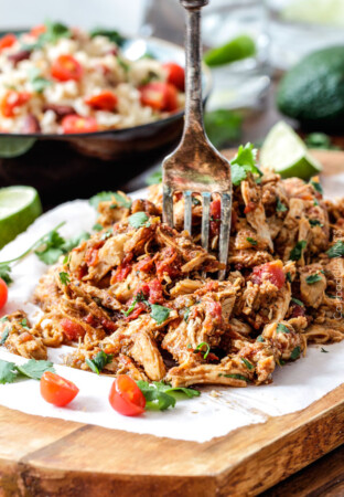 Easy Slow Cooker Shredded Mexican Chicken simmered with Mexican spices, salsa and green chilies for the BEST Mexican chicken perfect for tacos, burritos, tostadas, salads, etc. Couldn’t be any easier!