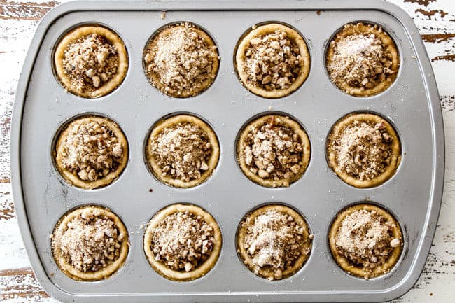 showing how to make caramel apple pie with streusel topping by adding streusel on top