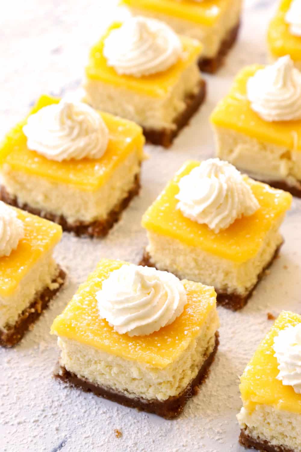 cheesecake bars with lemon curd topped with whipped cream