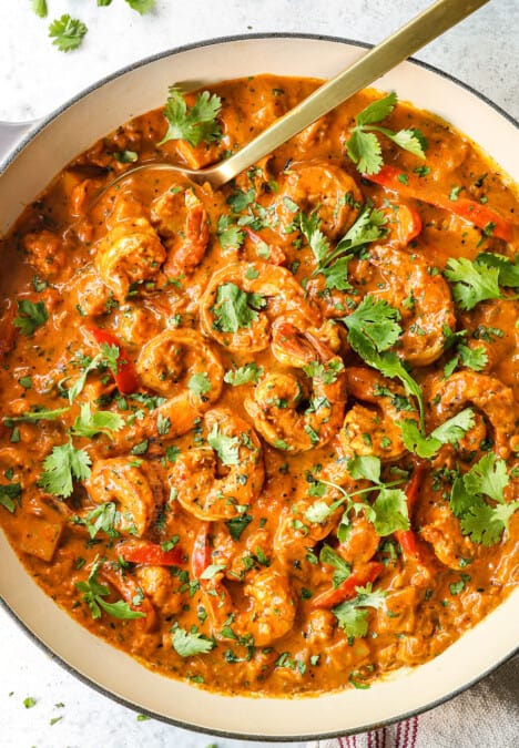 top view of cooking curry shrimp in a pan garnished with cilantro