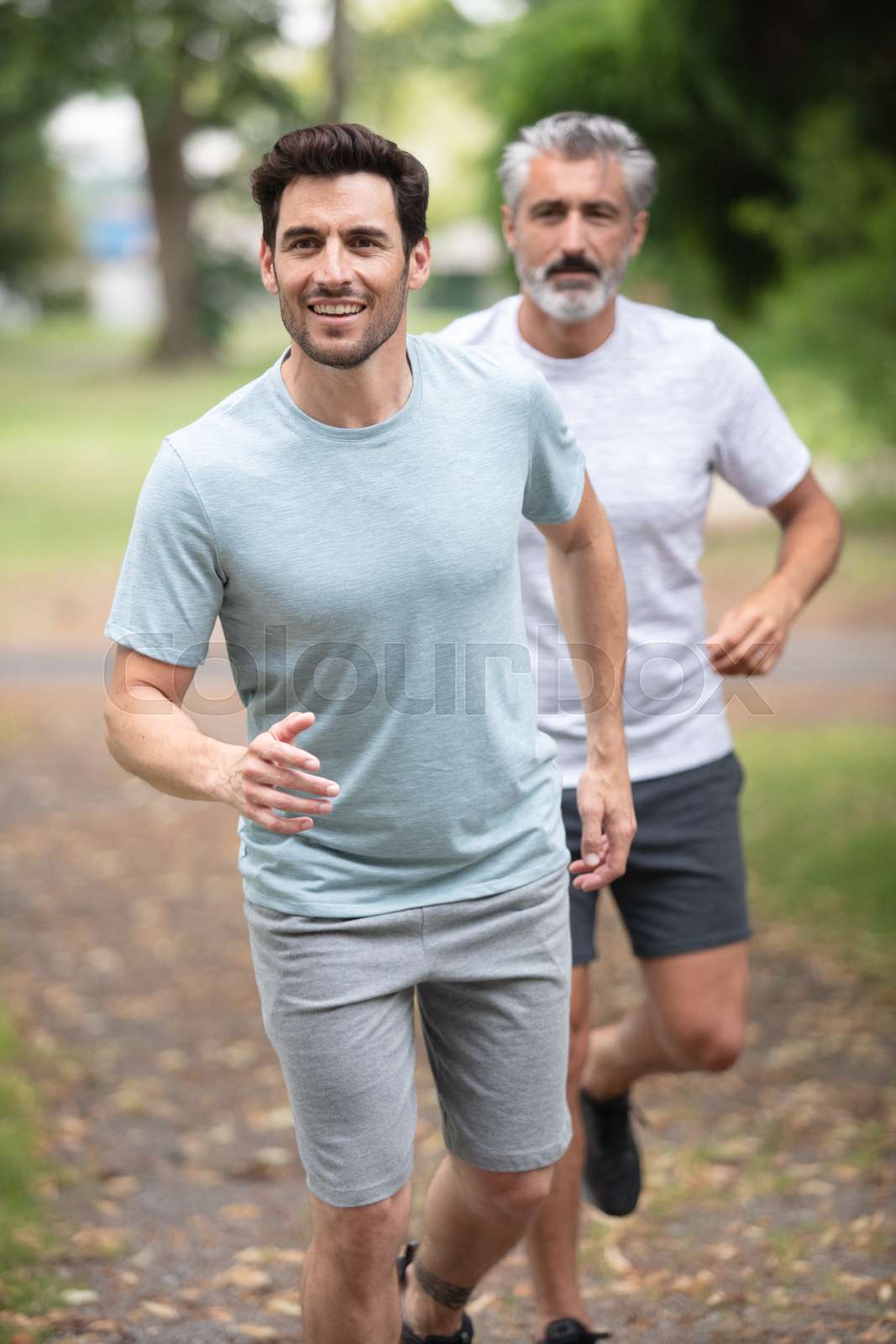 two men jogging in the park