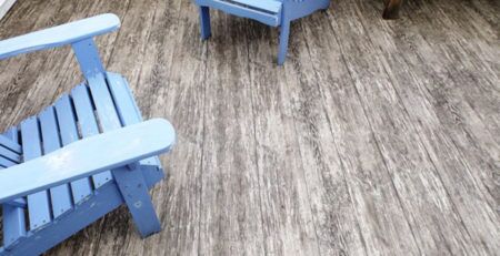 2 blue wooden lawn chairs on a newly covered vinyl wood plank deck