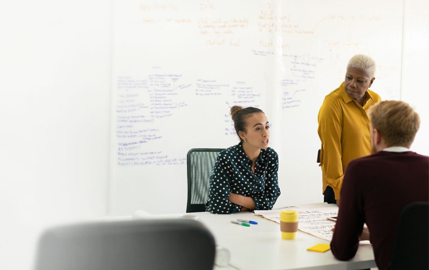 Three coworkers collaborating in a conference room.