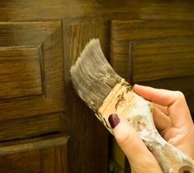 how to stain wood perfectly every time, hand moving brush against wood cabinet