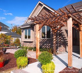 Custom cedar arbor enhances home's front entrance and paver patio provides sitting and gathering area.