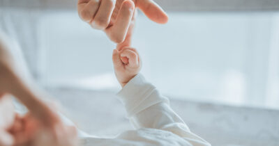 Baby holding mom hand. Credit / Shutterstock