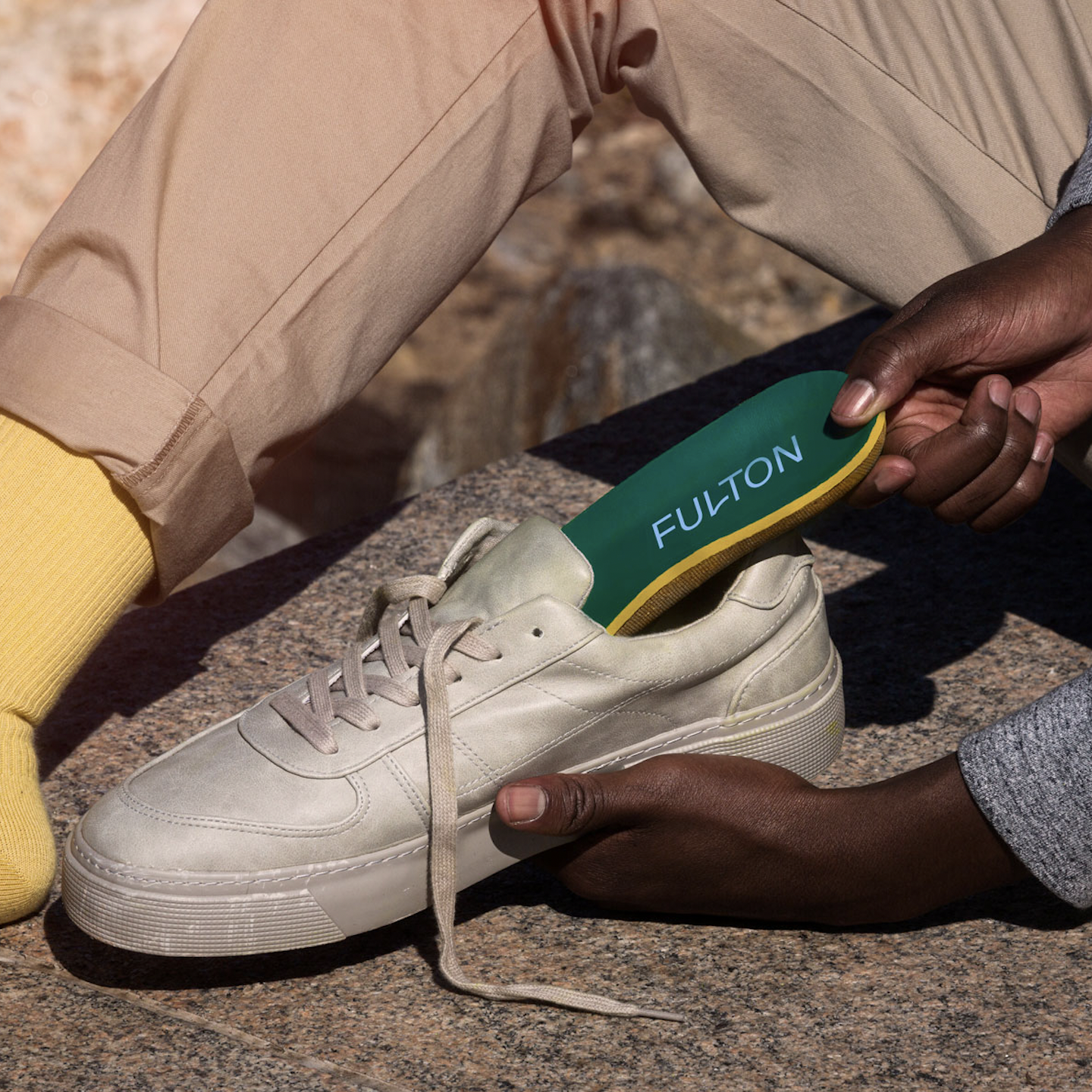 hand holding insoles placing into athletic footwear