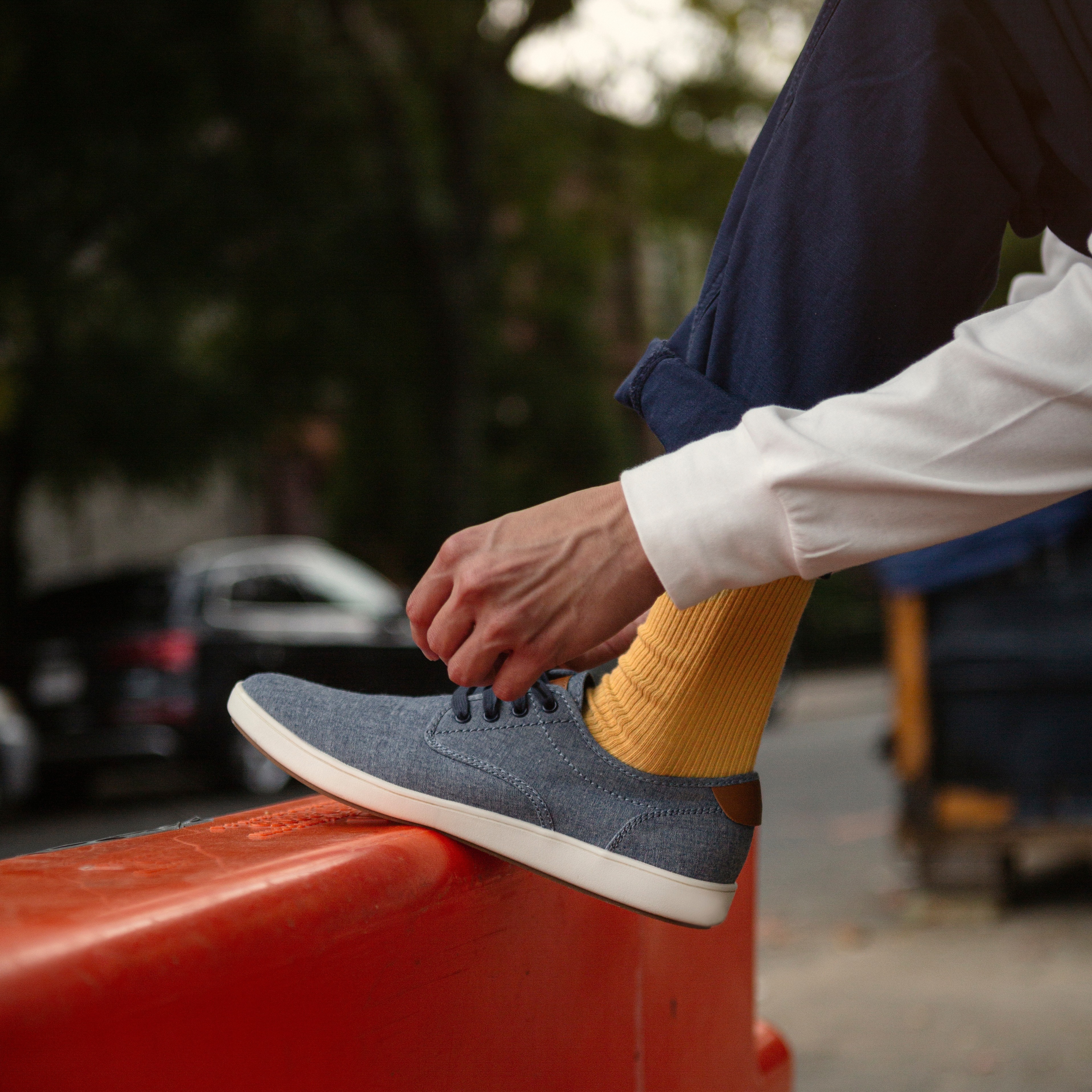 casual shoes with yellow socks and hands tying laces