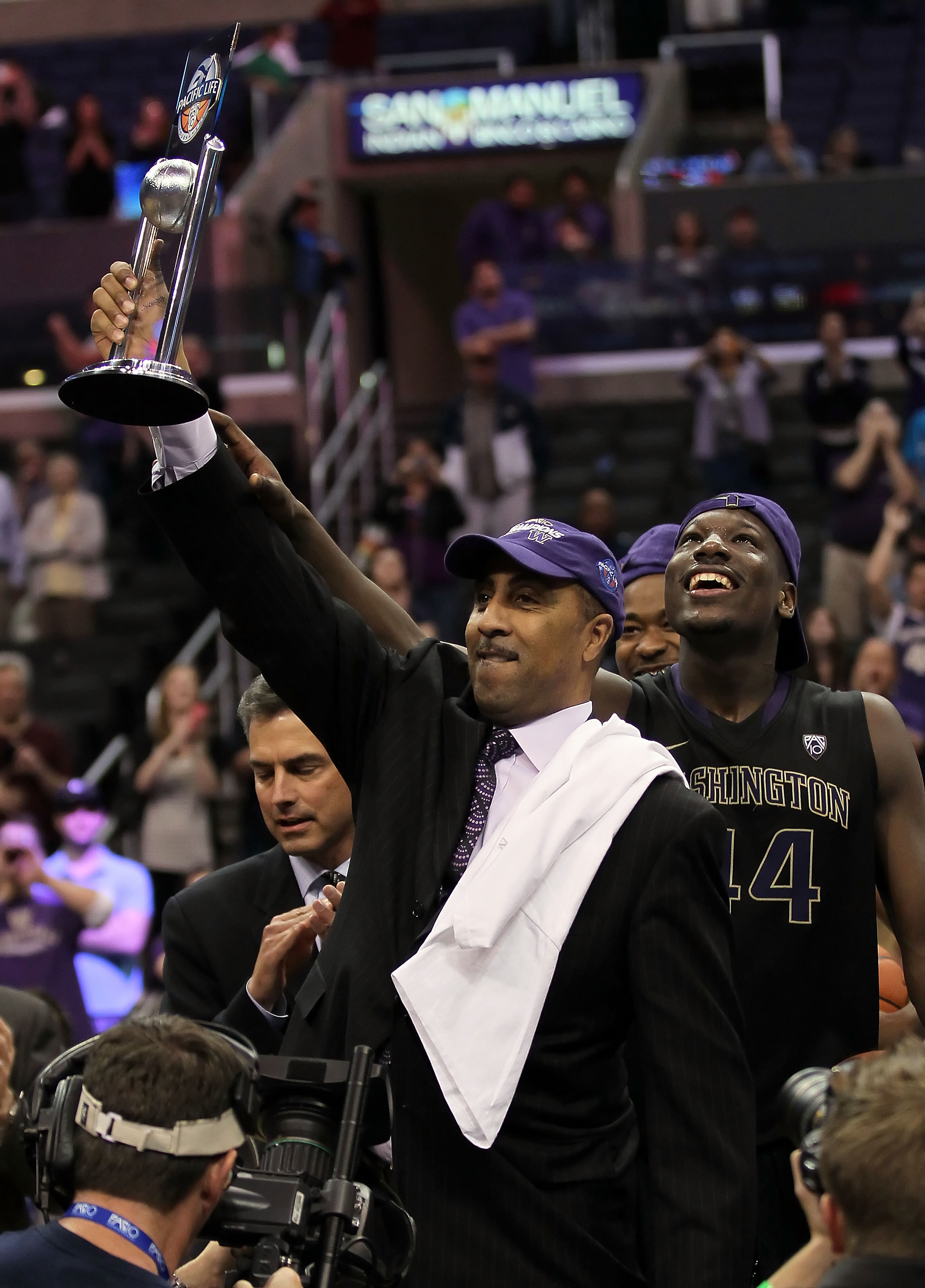 LOS ANGELES, CA - MARCH 12:  Head coach Lorenzo Romar of the Washington Huskies celebrates with the trophy after the Huskies defeated the Arizona Wildcats 77-75 in the championship game of the 2011 Pacific Life Pac-10 Men's Basketball Tournament at Staple