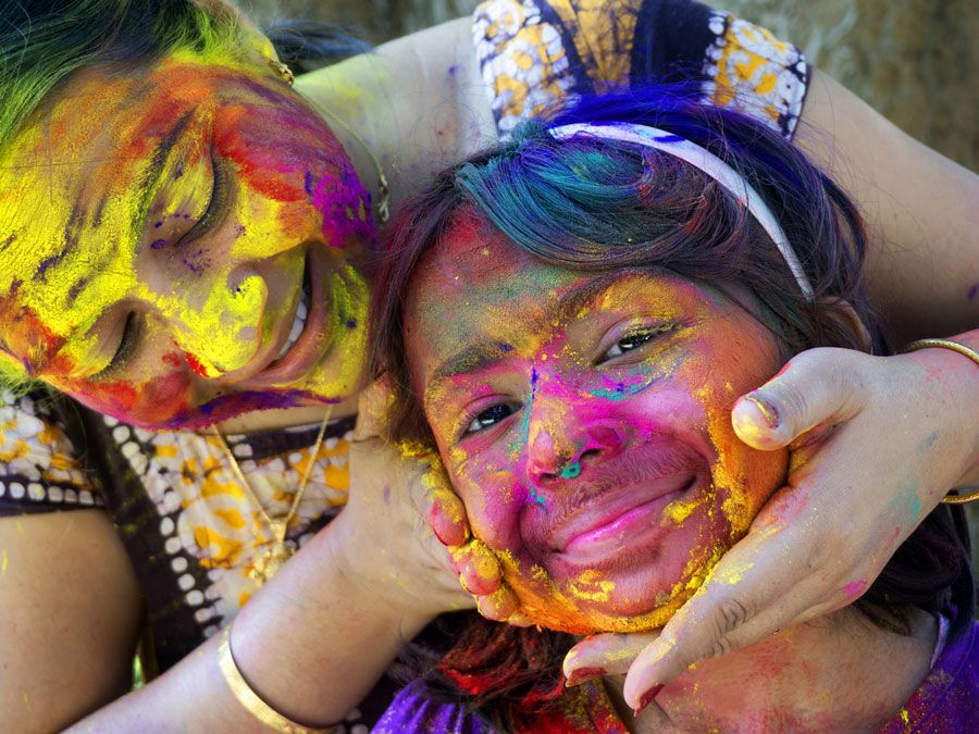 A woman and her daughter smear color powder on one another's face on Holi, the Indian festival of colors.