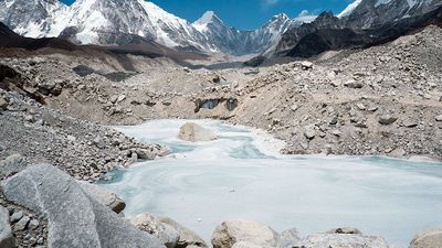 A frozen pond in the Khumbu Glacier with Pumori mountain in the left background, near Mount Everest in Sagarmatha National Park in the Himalayas, Nepal.