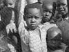 Video thumbnail image shows Black South African schoolchildren standing behind a fence.