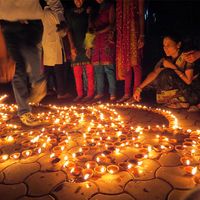 People lighting traditional earthen lamps during the Hindu festival Diwali in India. flame