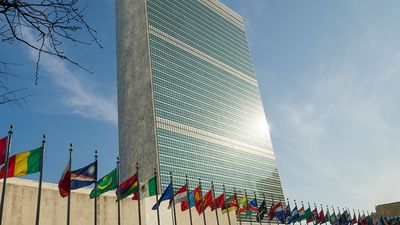 Secretariat Building at United Nations Headquarters with Members States' flags flying in the foreground, United Nations Headquarters, New York City, New York. (photo dated 2017)