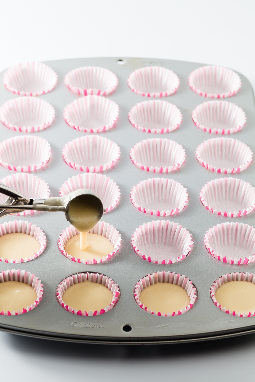 Filling mini cupcake liners with a disher